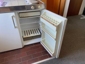 a small refrigerator with its door open in a kitchen at 3 Zimmer Wohnung in Isernhagen