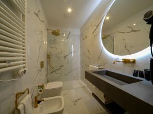a bathroom with a sink and a toilet and a mirror at Castiglioncello Suite in Castiglioncello +37 photos