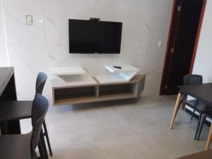 a living room with a tv and a table and chairs at Terraço Flecheiras in Flecheiras