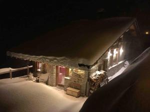 a house covered in snow at night with lights at La Rosière Magnifique chalet savoyard 160 m2 T5 in Montvalezan