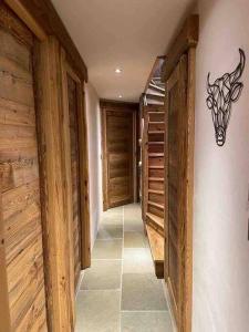 a hallway in a house with wooden walls and a chandelier at La Rosière Magnifique chalet savoyard 160 m2 T5 in Montvalezan