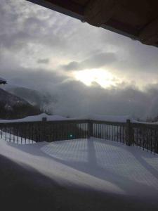 a snow covered deck with a fence and the sky at La Rosière Magnifique chalet savoyard 160 m2 T5 in Montvalezan