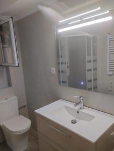 a bathroom with a sink and a toilet and a mirror at Casa Tower in Vigo