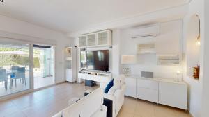 sala de estar con muebles blancos y TV en La Torre Villa Bacalao - A Murcia Holiday Rentals Property, en Roldán