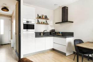 una cucina bianca con lavandino e tavolo di Atmospheric apartment Zaandam/Amsterdam a Zaandam