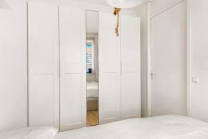 1 dormitorio con armarios blancos y espejo en Atmospheric apartment Zaandam/Amsterdam, en Zaandam