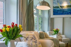 a living room with a couch and a vase of flowers at 40 Trelawny Way in Bembridge
