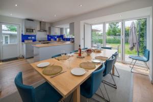 a kitchen and dining room with a wooden table and chairs at 40 Trelawny Way in Bembridge