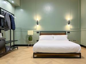 - une chambre avec un grand lit blanc et une télévision dans l'établissement Mondo7, à Bologne