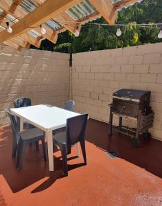 a table and chairs and a grill in a backyard at Alojamiento El Cóndor in Esquel