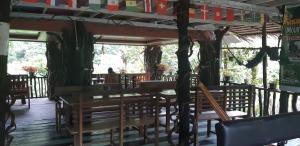 a restaurant with a table and chairs on a wooden deck at Mountain View Cottages & Villa Tangkahan in Tangkahan