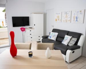 a living room with a couch and a table at Hotel La Ciotat - A deux pas de l'eau in La Ciotat