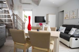 a living room with a dining room table with a red vase at Hotel La Ciotat - A deux pas de l'eau in La Ciotat