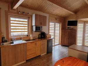a kitchen with wooden cabinets and appliances in a cabin at Domki drewniane pod Karpaczem in Mysłakowice
