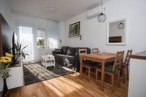 een woonkamer met een tafel en een bank bij Apartman Domagoj in Osijek