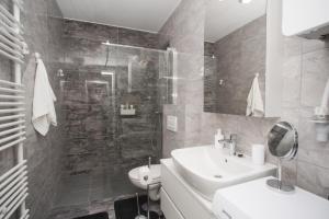 een witte badkamer met een wastafel en een douche bij Apartman Domagoj in Osijek +13 foto's