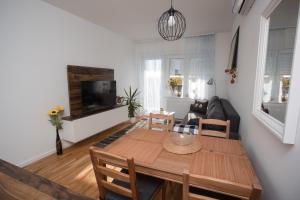 een woonkamer met een houten tafel en een bank bij Apartman Domagoj in Osijek