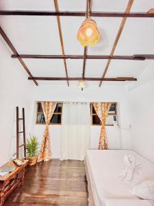 Burgos的住宿－Precious Homestay (Deluxe Room)，一间卧室配有一张床和一个吊灯