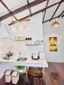 a kitchen with white counters and a sink at Precious Homestay (Deluxe Room) in Burgos