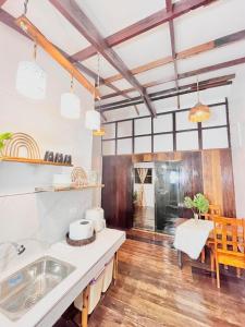 a kitchen with white counters and a table and a dining room at Precious Homestay (Deluxe Room) in Burgos