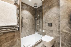 a bathroom with a toilet and a shower at Dakota Leeds in Leeds