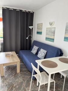 ein Wohnzimmer mit einem Sofa und einem Tisch in der Unterkunft La Cascada 410 in Puerto Rico de Gran Canaria