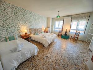 um quarto com 2 camas e 2 cadeiras em Casa Rural Teralba 2 em La Calzada de Oropesa