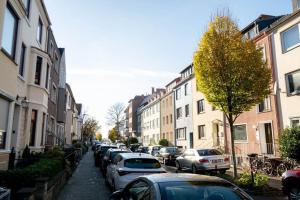 uma rua da cidade com carros estacionados e edifícios em EXKLUSIVE 2-Zimmer Wohnung Bremen Neustadt 6 em Bremen