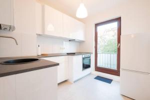 uma cozinha branca com um lavatório e uma janela em EXKLUSIVE 2-Zimmer Wohnung Bremen Neustadt 6 em Bremen