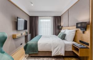 a hotel room with a bed and a television at Rent like home - Deo Plaza Wyspa Spichrzów in Gdańsk