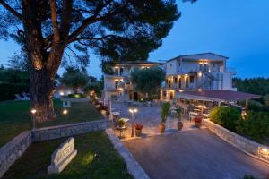 a large white building with a tree in front of it at Mirabilia Boutique Hotel in Kriopigi