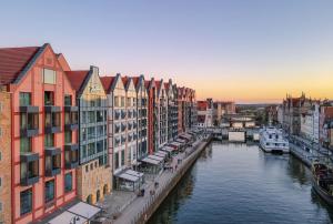 a view of a river with buildings and boats at Deo Plaza Premium by Rent like home in Gdańsk