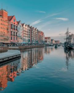 Blick auf einen Fluss mit Gebäuden und eine Stadt in der Unterkunft Deo Plaza Premium by Rent like home in Danzig