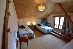 a bedroom with two beds in a attic at Maison au coeur des Bauges in Aillon-le-Jeune
