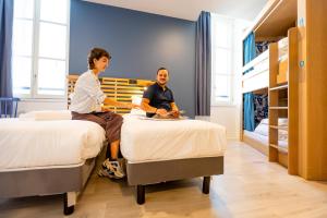 two people sitting on beds in a bedroom at The People - Marseille in Marseille +53 photos