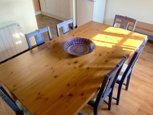 una mesa de madera con sillas y un bol en la parte superior en Cider Cottage - 3 Bedroom - Onsite Parking, en Sidmouth