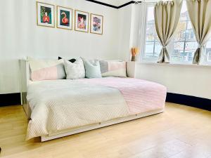 a bedroom with a bed with pink and white sheets at Rest Boutique Golders Green in London