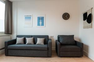 a living room with a couch and a chair at Homaris Apartments Hamburg Altona in Hamburg