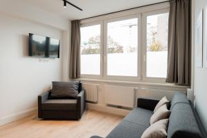 a living room with a couch and a chair and a window at Homaris Apartments Hamburg Altona in Hamburg