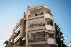 wysoki biały budynek z balkonem w obiekcie Cozy apartment in Sykies w Salonikach