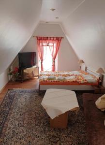 Un dormitorio con una cama y un televisor y una ventana. en Pension Birgit, en Rothenburg ob der Tauber