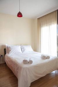 sypialnia z białym łóżkiem i 2 ręcznikami w obiekcie Cozy apartment in Sykies w Salonikach