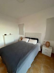 a bedroom with a large bed and two night stands at Triplex Meloneras-Amplio,soleado in Maspalomas