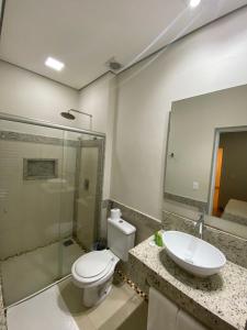 a bathroom with a toilet and a sink at Hotel Recanto dos Ipes in Frutal