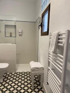 a bathroom with a toilet and a chair and a shower at Casa Rural Dolly Baby in Alarcón