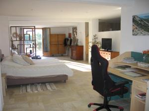 Schlafzimmer mit einem Bett, einem Schreibtisch und einem Stuhl in der Unterkunft Les Genêts in Fayence