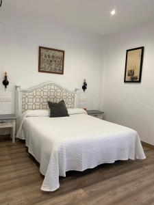 een slaapkamer met een groot wit bed met witte lakens bij Casa Rural Dolly Baby in Alarcón