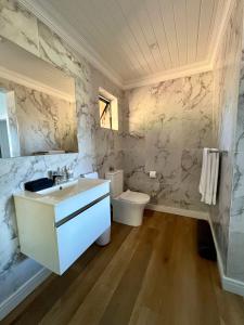 a bathroom with a sink and a toilet at The Milkwoods Luxury Living in Mossel Bay