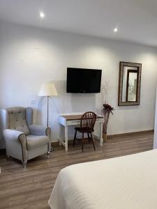 a hotel room with a desk and a chair and a television at Casa Rural Dolly Baby in Alarcón