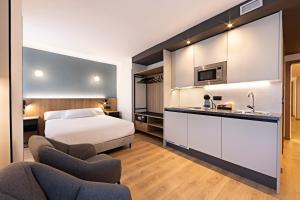 pokój hotelowy z łóżkiem i kuchnią w obiekcie Apartahotel Colón 27 w mieście Palencia
